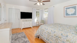 A bedroom with a bed, a ceiling fan, a TV, a dresser, a chair, and a window with curtains. - Hershey's Hideaway: A Tranquil Retreat on the Hill (Palmyra)