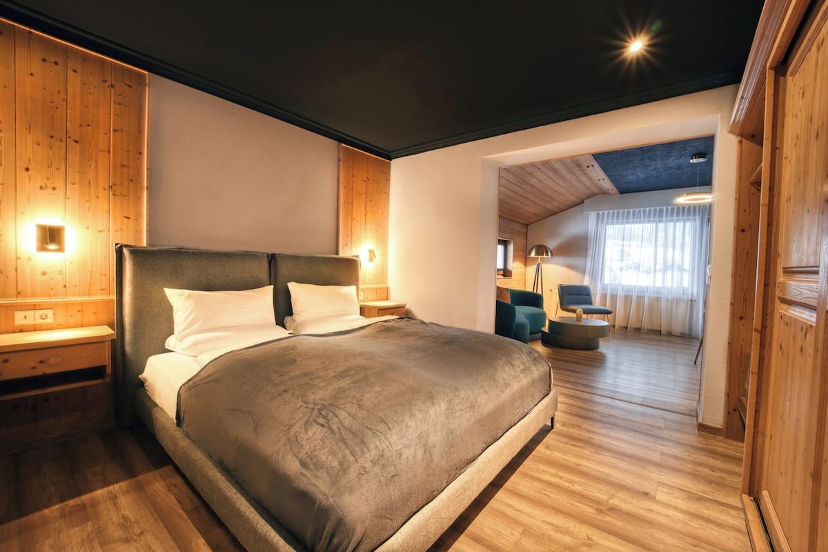 Ein modernes Schlafzimmer mit einem großen Bett, Holzwänden und einer Decke mit freiliegenden Balken.