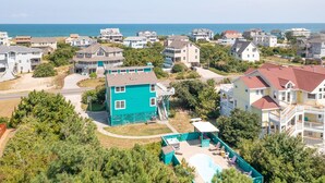 A coastal residential area with houses, a swimming pool, and a view of the ocean. - Pet-friendly oceanside Corolla home w/ private pool & hot tub! (Corolla)