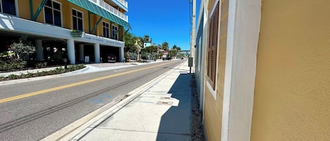 Vista de una calle con un edificio que tiene un balcón y un cartel que dice 'Welcome to Paradise'.