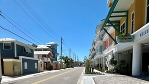 Vista de una calle en una zona costera con edificios coloridos, incluyendo un hotel llamado 'Margaritaville Beach Resort' con un letrero.