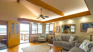 A spacious living room with a wooden ceiling, a sofa set, a coffee table, and a view through large windows. - Mallard Island home.  located at 1375 e mallard dr Manahawkin 08087            (Stafford Township)