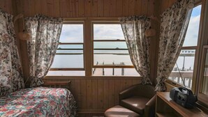 A cabin with a bed, a chair, a radio, and a window with a view of a dock and water. - Mallard Island home.  located at 1375 e mallard dr Manahawkin 08087            (Stafford Township)
