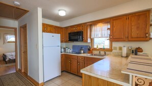 A kitchen with wooden cabinets, a white refrigerator, a microwave, and a sink. - Mallard Island home.  located at 1375 e mallard dr Manahawkin 08087            (Stafford Township)