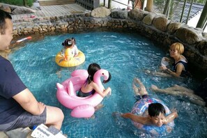 Una piscina con juguetes inflables y personas.