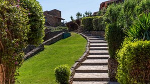 A stone staircase leading up a grassy slope, surrounded by lush greenery and stone walls. - Punta Est - 2BR GINESTRA Family & Pool (Capo Coda Cavallo)