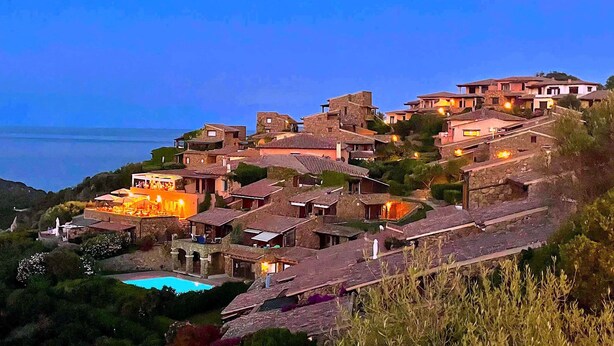 A hillside village with stone buildings, a swimming pool, and a view of the sea. - Punta Est - 2BR BOUGANVILLE 300m From The Beach & Pool (Capo Coda Cavallo)
