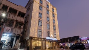 Een hotel met een bord waarop 'THE CAPITAL HOTEL' staat en een zichtbare ingang.