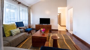 Ein modernes Wohnzimmer mit einer Couch, einem Couchtisch, einem Fernseher und einem Holzschrank.