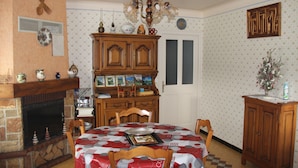 A dining room with a fireplace, wooden cabinets, and a checkered tablecloth.