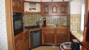 A kitchen with wooden cabinets, a dishwasher, a stove, and a microwave.