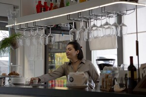 Zona de bar con mostrador, copas de vino y una taza de café.