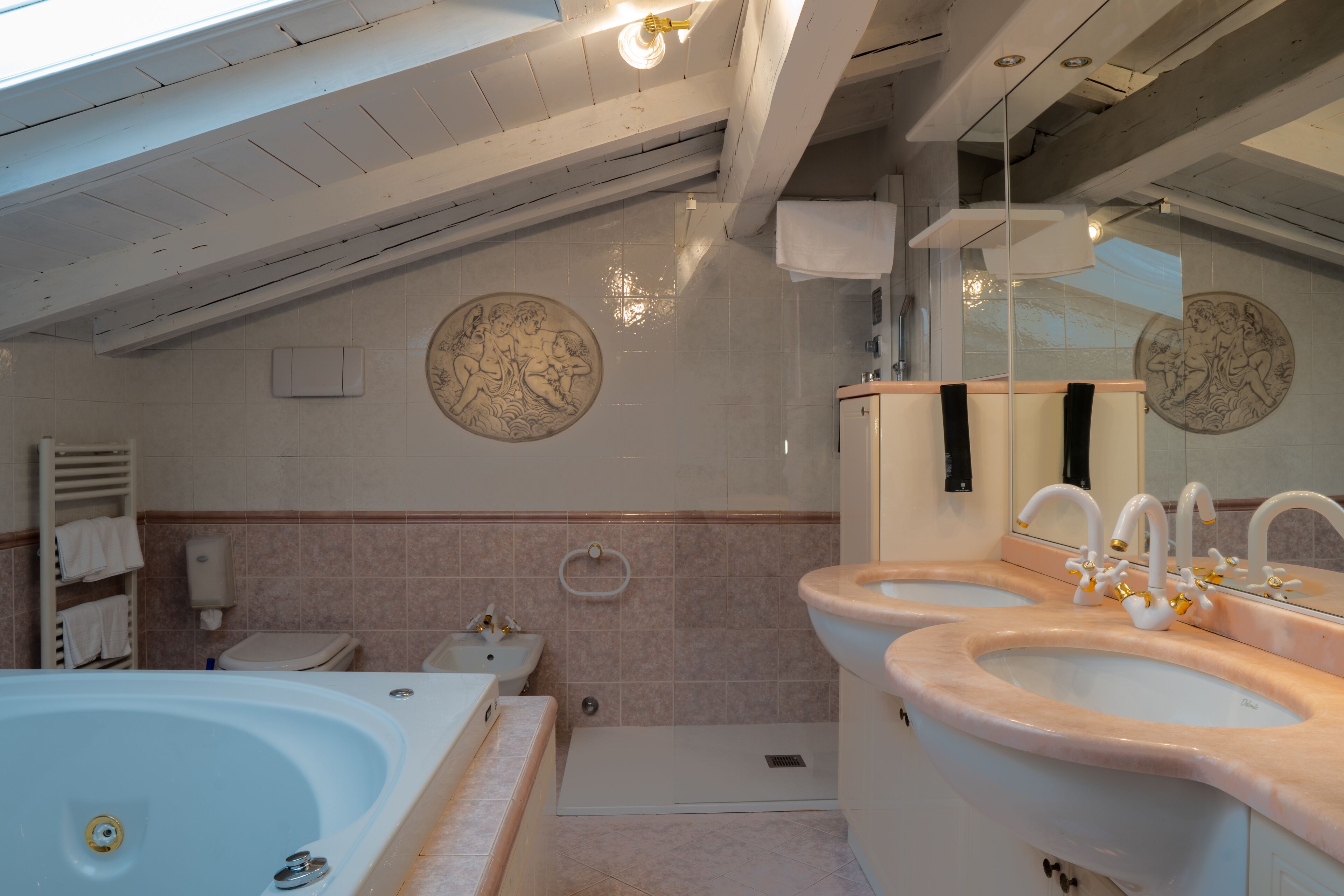A bathroom with a bathtub, two sinks, a toilet, and a shower.