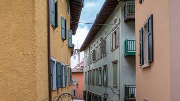 Una calle estrecha flanqueada por edificios con balcones y contraventanas.