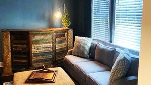Ein gemütliches Wohnzimmer mit einer Couch, einem kleinen Tisch und einem dekorativen Schrank.