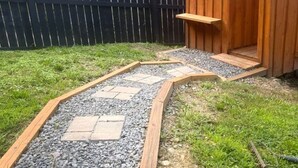 Ein Gartenpfad mit trittsteinförmigen Steinen und einer Holzterrasse.