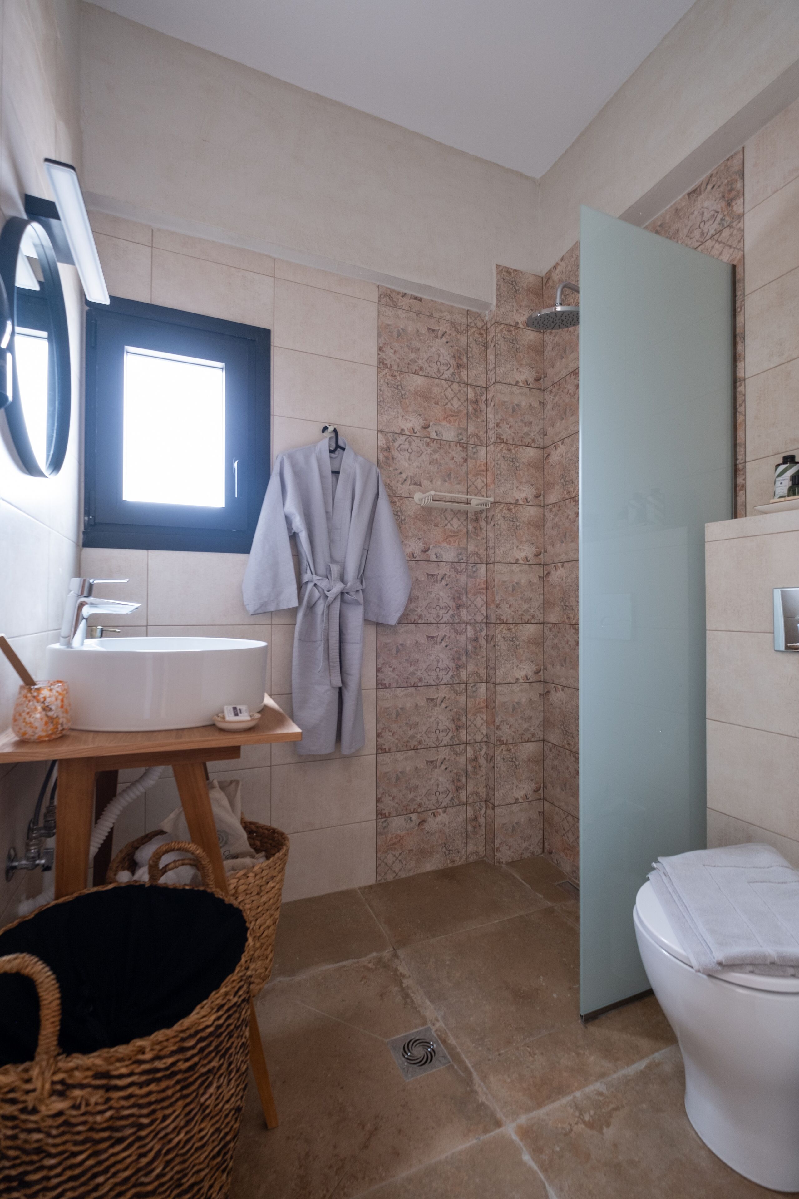 Un baño con lavamanos, espejo y zona de ducha.