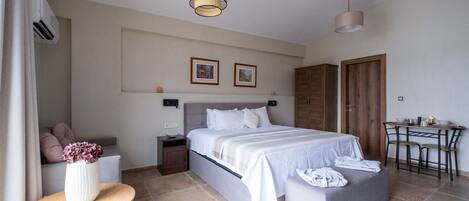 A modern bedroom with a large bed, bedside tables, a small desk, and a wardrobe.