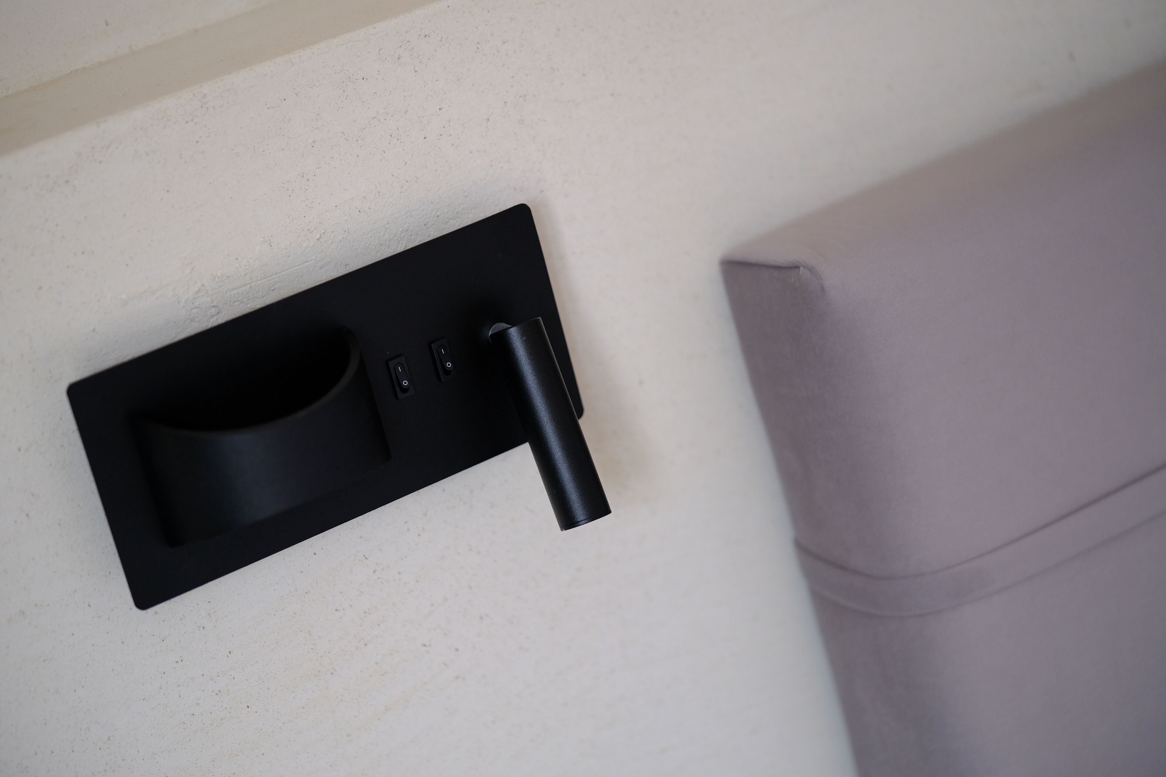 A black wall-mounted charging station with a cup holder and USB ports.