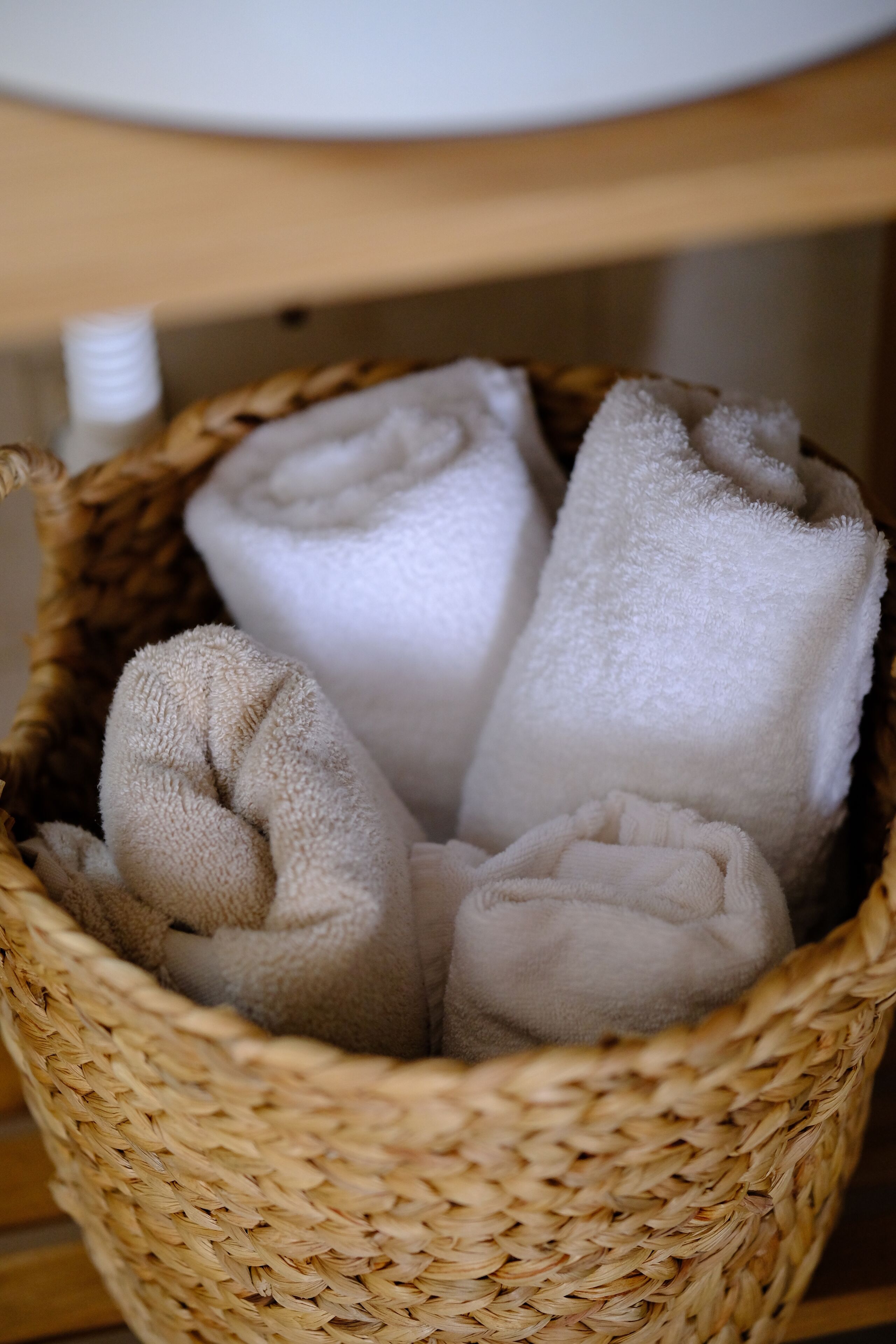 A woven basket containing rolled towels.