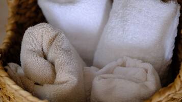 A woven basket containing rolled towels.