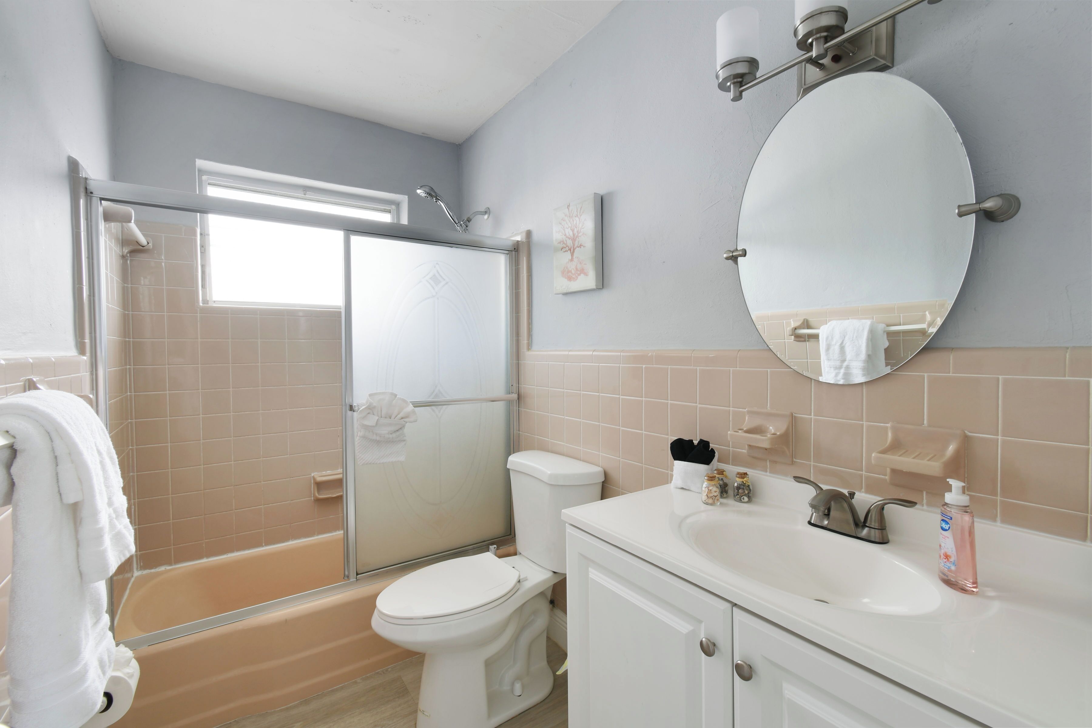 Une salle de bain équipée d’une douche, de toilettes, d’un lavabo et d’un miroir.