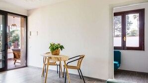 A modern living room with a dining area, a green sofa, and a wooden floor. - Villetta Sirena a Fontane Bianche (Syracuse)