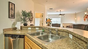 A kitchen with granite countertops, stainless steel appliances, and a dishwasher. - 2 Miles to Disney Condo w/ Balcony - Pool - Gym (Kissimmee)