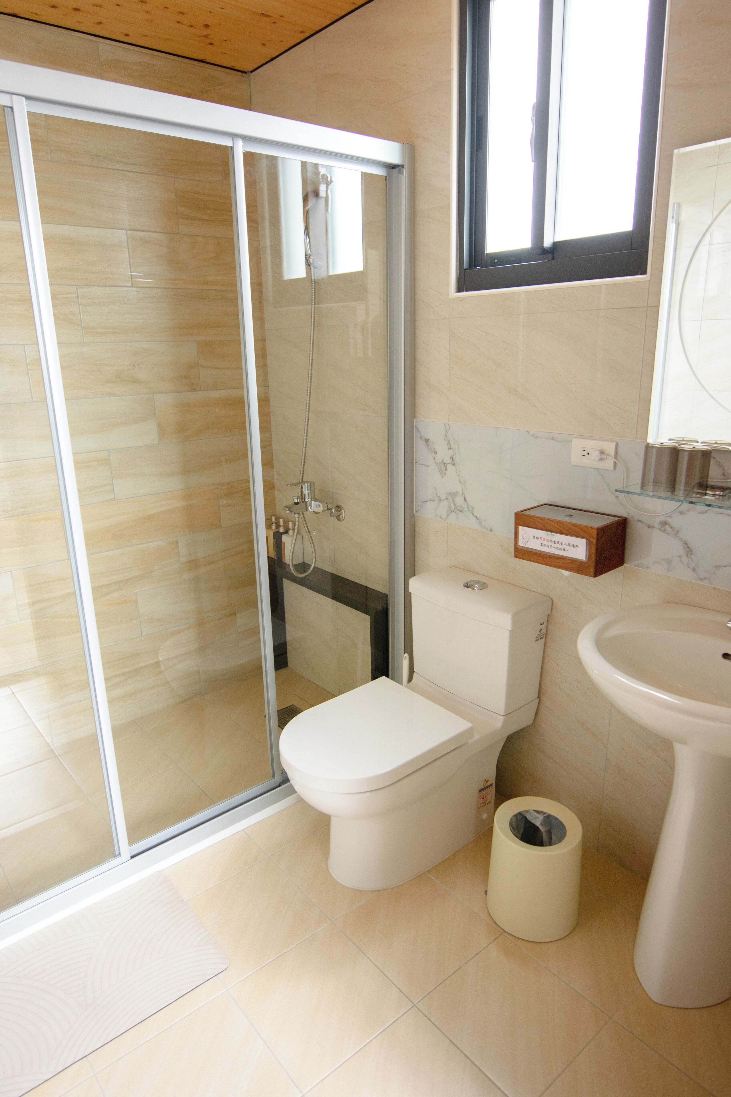 Un baño moderno con cabina de ducha de vidrio, inodoro, bidé y lavamanos.