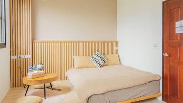 Un dormitorio con cama, mesita de noche con botellas, lámpara y cabecero de madera.