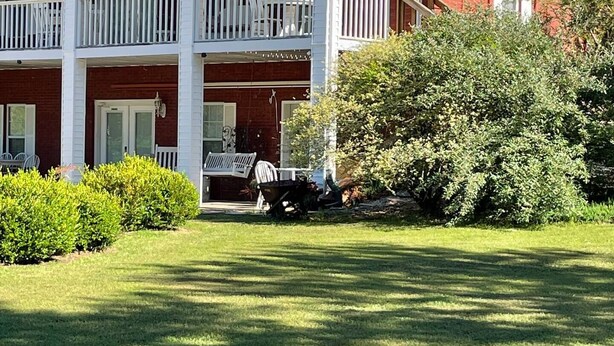 A two-story brick building with a white balcony on the second floor. - Hank Williams hang out (Camden)
