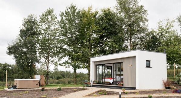 A modern, single-story building with a minimalist design, featuring large glass windows and a flat roof.