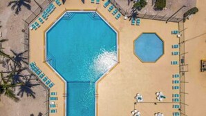 An octagonal pool with a smaller adjacent pool, surrounded by lounge chairs and palm trees. - Empty RV Lot with Amazing Views! (Cudjoe Key)