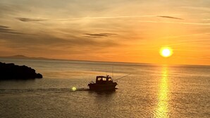 Ein Boot auf ruhigem Wasser bei Sonnenuntergang.