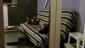 Ein Schlafzimmer mit Bett, kleinem Schreibtisch, Stuhl und Kleiderschrank.