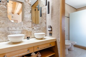 A bathroom with two sinks, a mirror, and a toilet.