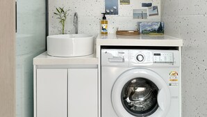 Un espacio pequeño con lavadora, pileta y un mueble bajo.