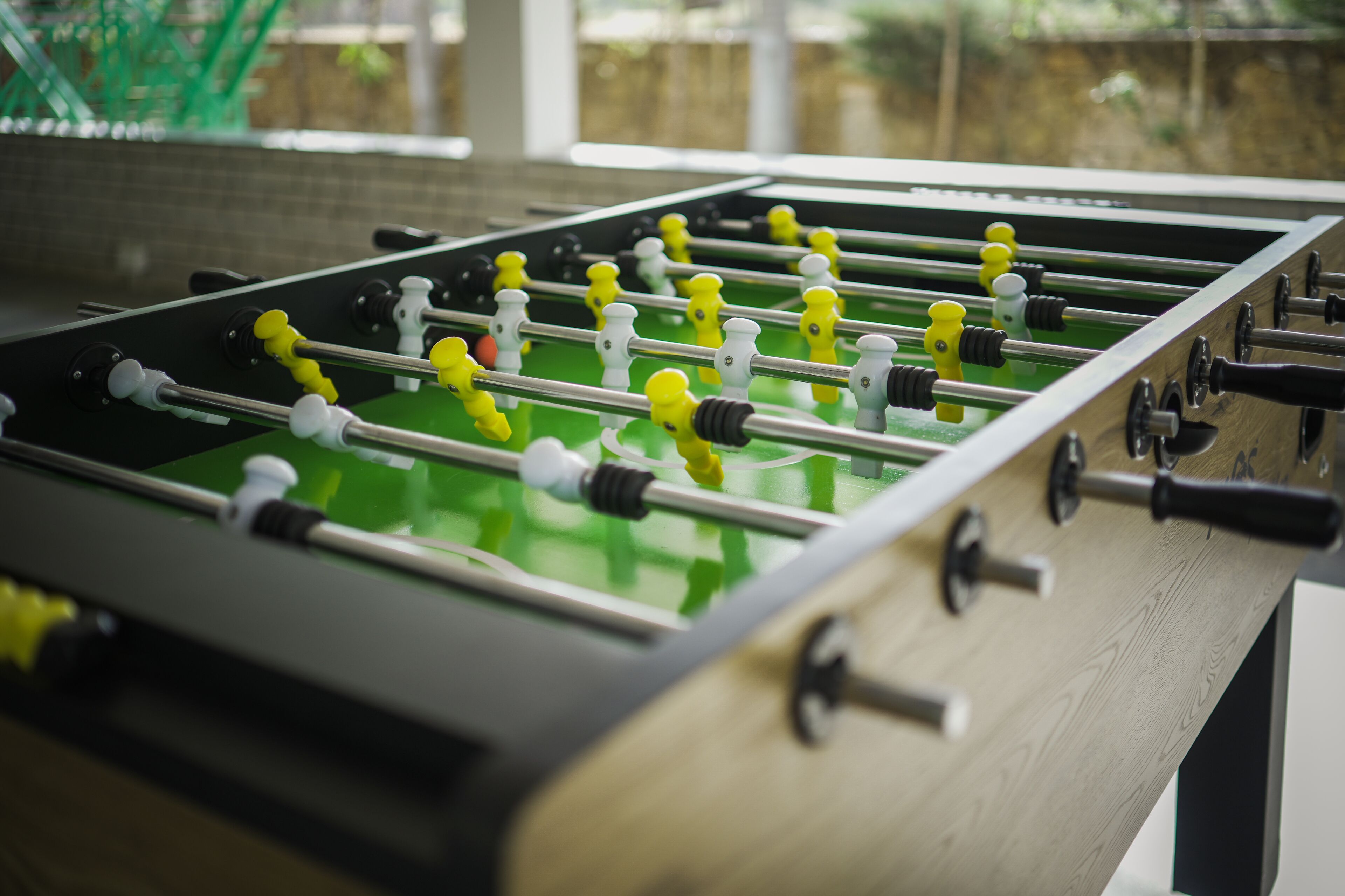 Un tavolo da calcio inglese con struttura in legno e superficie di gioco verde.