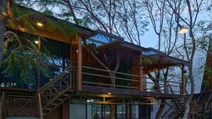 A wooden building with a balcony, stairs, and a glass door. - Visamo Nalsarovar Resort Ahmedabad (Bavla)