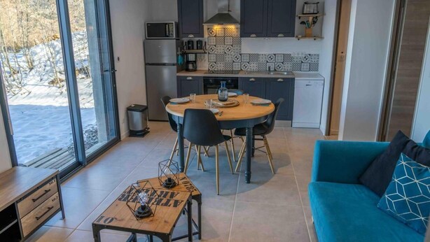 A modern kitchen with a dining area, a blue sofa, and a table with a lamp. - 350m from ski slopes, tv, ski locker, 51m², Les Orres (Les Orres)