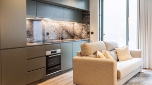 A modern kitchen with a built-in oven and a large window.