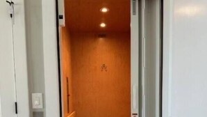 Ascensore con interni in legno e esterno bianco.