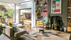 A modern living room with a fireplace, bookshelves, and a sofa. - Beautifully Curated 4 Bed Family Home w/ Garden (London)