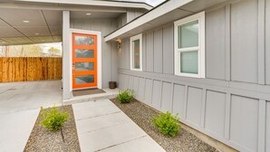 A modern house with a grey exterior, a wooden fence, and a concrete pathway leading to a door with a glass panel. - Boise Retreat ~ 2 Mi to Boise State University! (Boise)