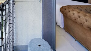 A modern hotel room with a large bed, a small balcony with a metal railing, and a view of the cityscape. - Studio Vila Nova (São Paulo)