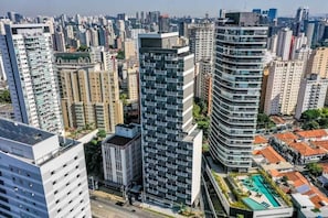 A high-rise urban area with modern buildings, a swimming pool, and a busy street.