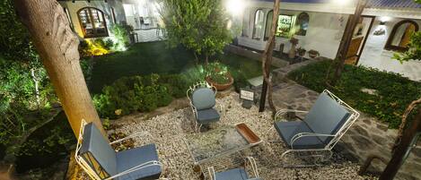 A patio area with outdoor seating, a small table, and a potted plant.