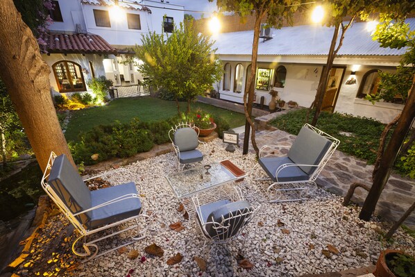 A patio with outdoor furniture, a small table, and a potted plant. - Posada de Rosas (Mendoza)