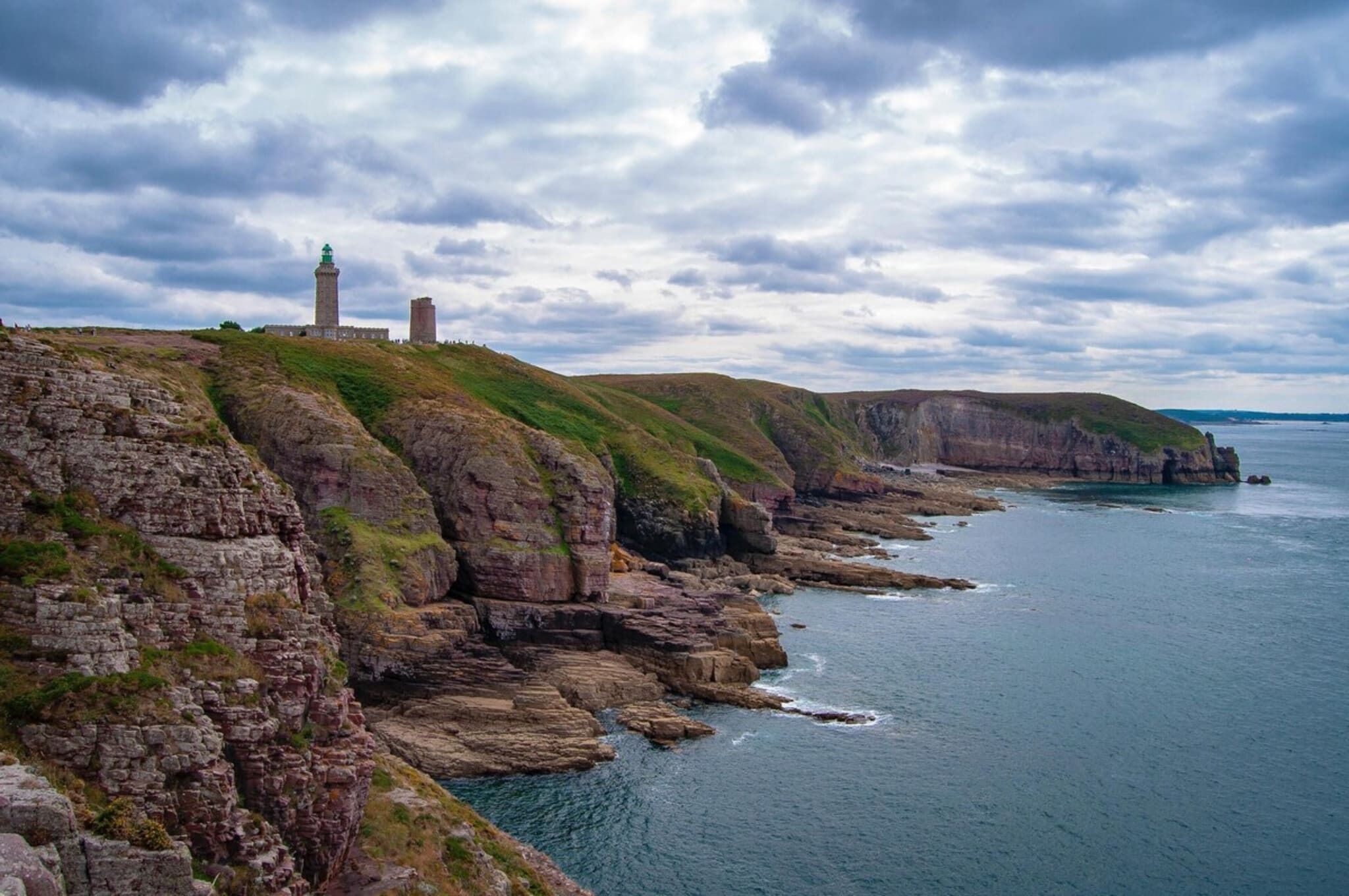 A coastal landscape with rocky cliffs and a lighthouse.