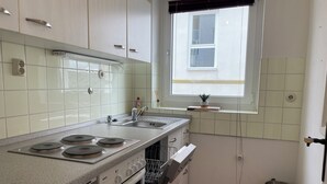 Cozinha com fogão Bosch, máquina de lavar louça e janela com vista.